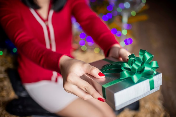 midsection-woman-holding-gift-box-christmas_1048944-27264327